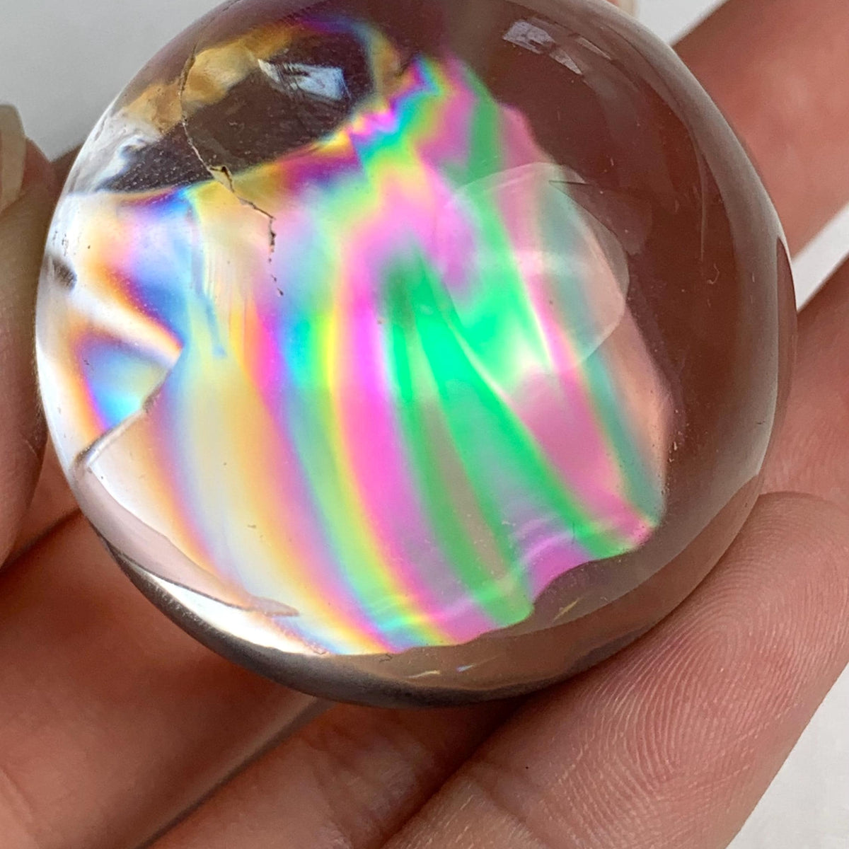 Polished rainbow quartz sphere ideal for crystal collectors and display