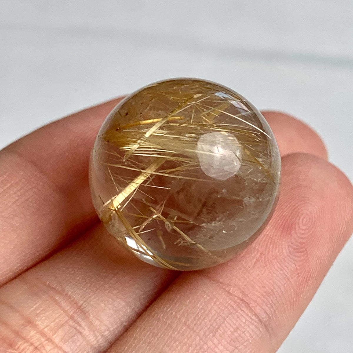 Compact golden rutile quartz sphere ideal for meditation or display
