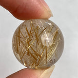 Small collector rutilated quartz sphere showing vivid golden inclusions