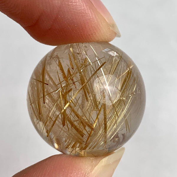 Small collector rutilated quartz sphere showing vivid golden inclusions