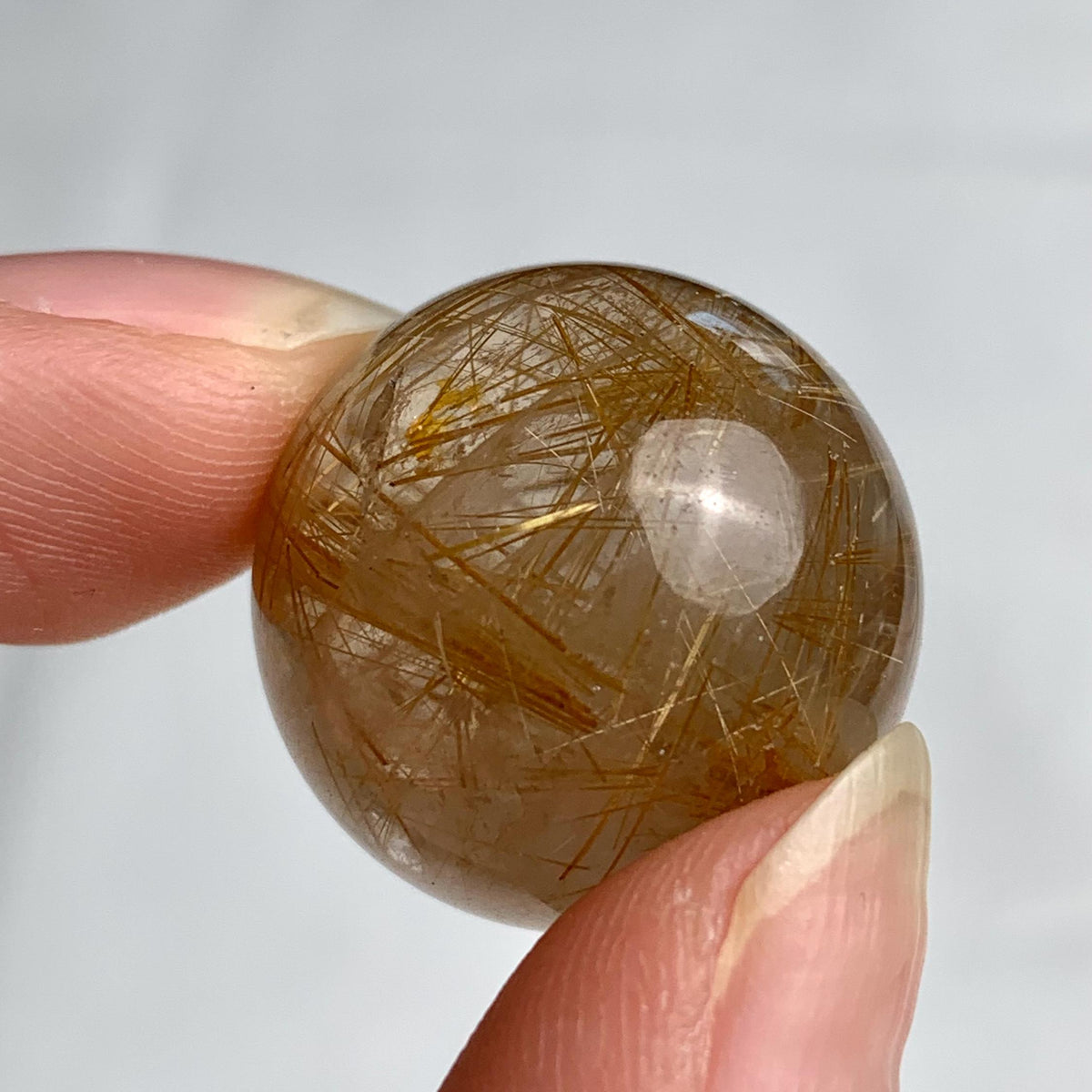 21mm natural quartz crystal ball showing bright internal rutile inclusions and shimmer effect