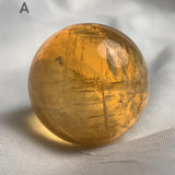 Honey calcite sphere displaying natural rainbow flash
