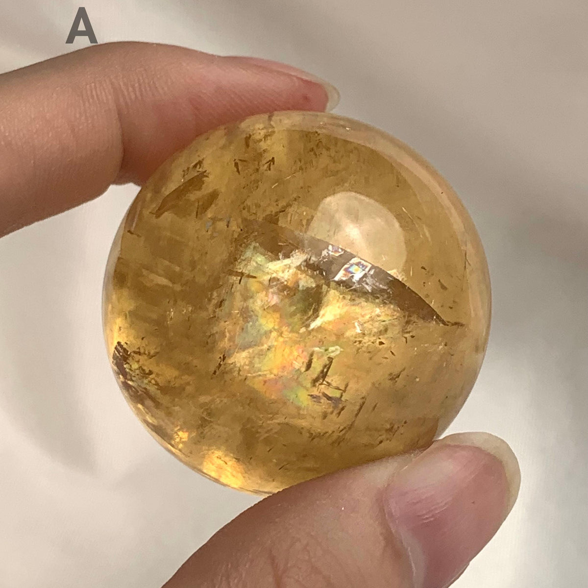 Natural calcite sphere with golden yellow tones
