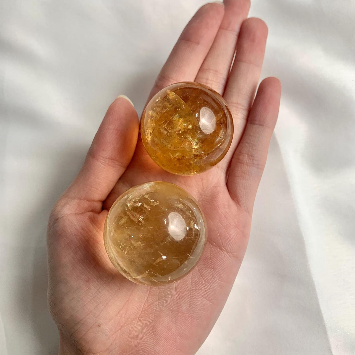 Honey calcite sphere with rainbow inclusions