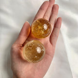 Honey calcite sphere with rainbow inclusions
