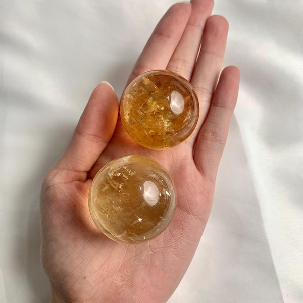 Honey calcite sphere with rainbow inclusions