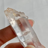 Natural Lemurian quartz point displayed on a white background