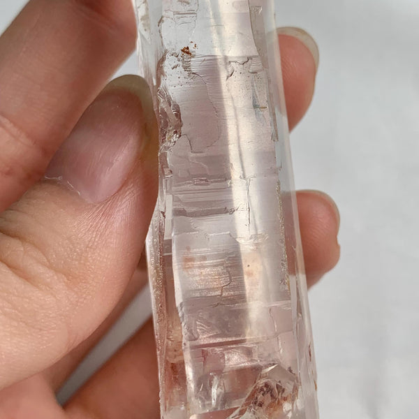 Transparent Lemurian Quartz point displayed on white background