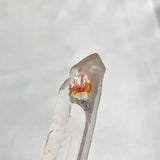 Clear quartz specimen with golden mineral inclusions