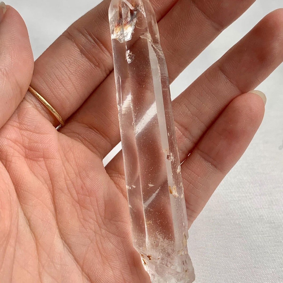 Natural quartz crystal wand displayed on white background