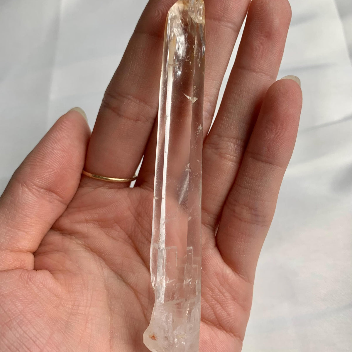 Clear quartz specimen with golden mineral inclusions