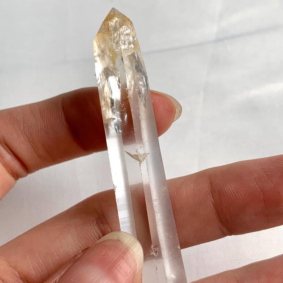 Clear quartz specimen with golden mineral inclusions