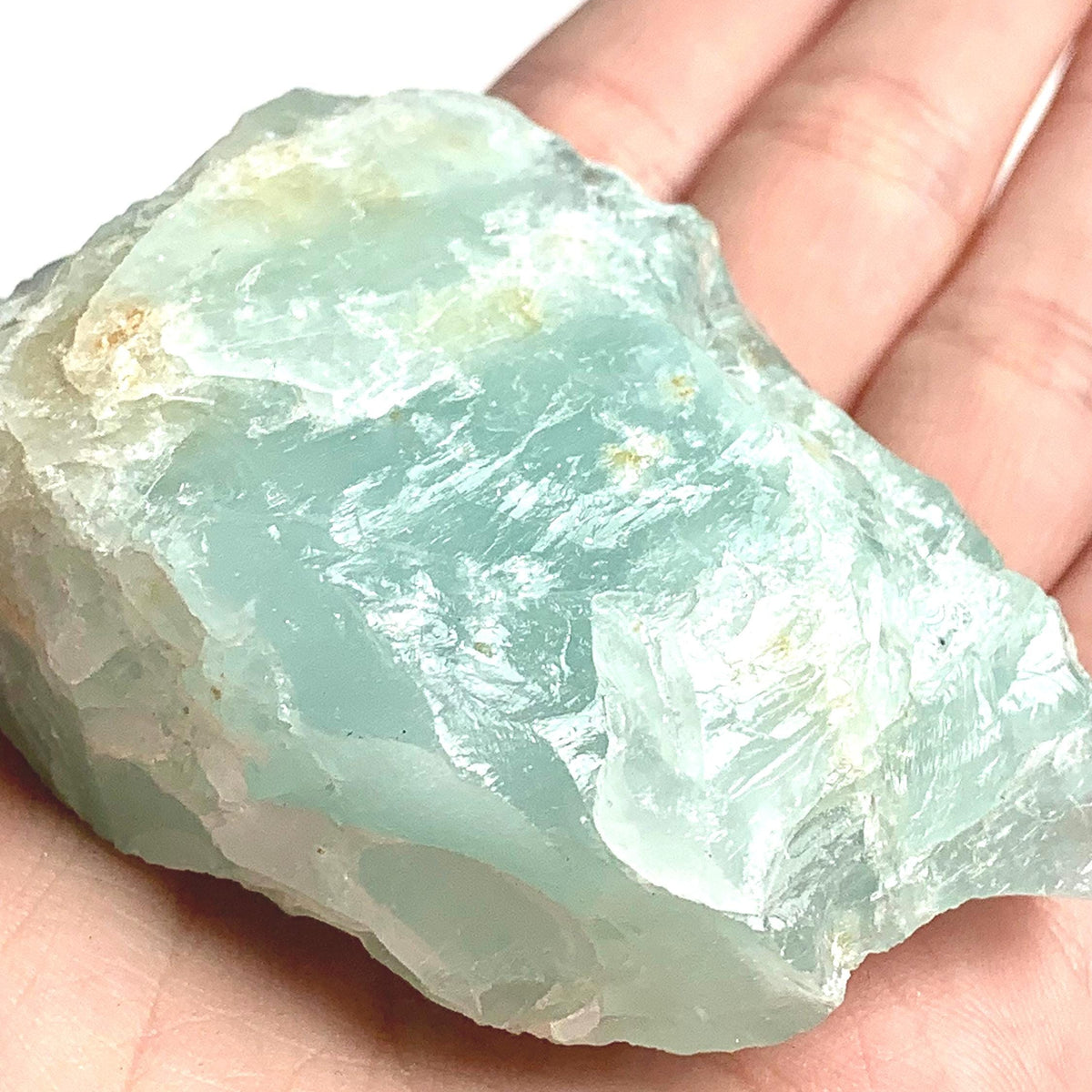 Large rough aquamarine crystal displayed on a white background