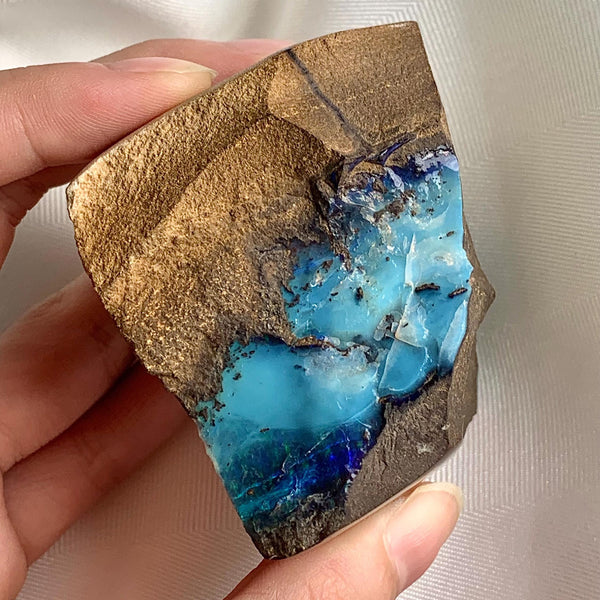 Australian boulder opal rough specimen with vibrant blue green opal seams