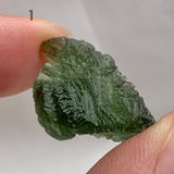 Raw Moldavite stone displaying natural etched surface details