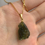 Natural unpolished moldavite jewelry showcasing authentic surface features