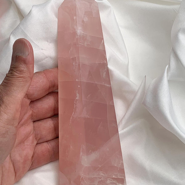 Large pink rose quartz obelisk tower with square base on white background