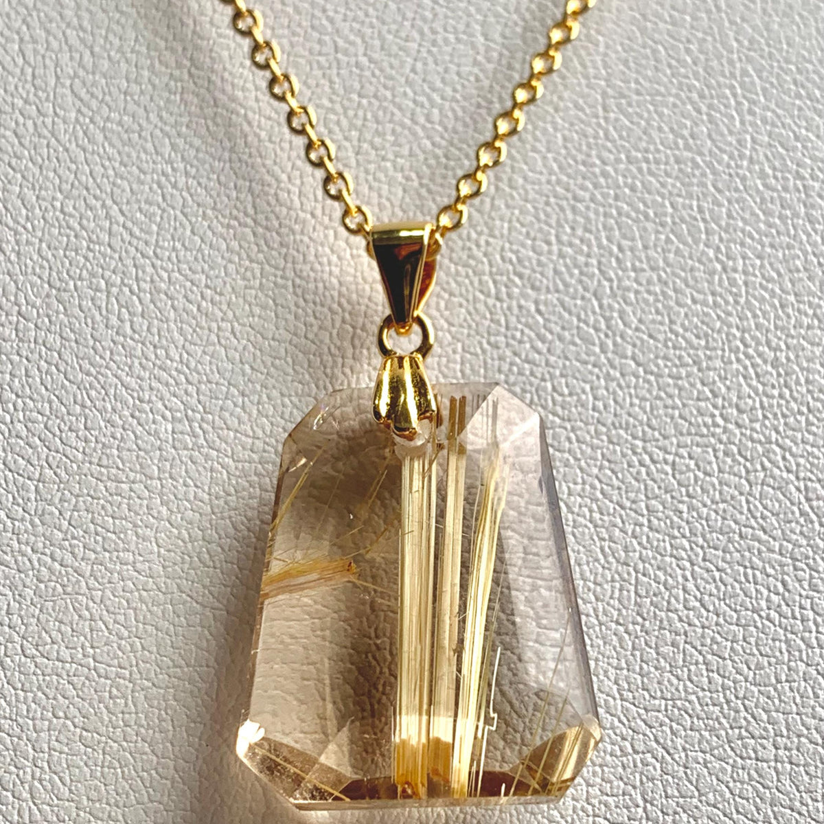 Faceted trapezoid Rutilated Quartz necklace showing natural golden rutile threads