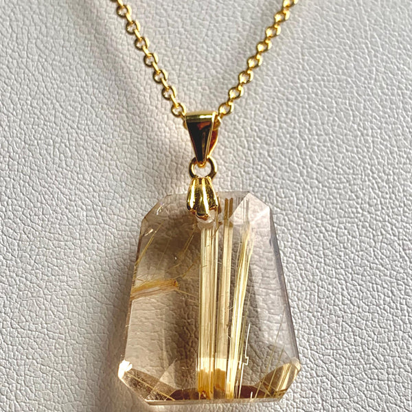 Faceted trapezoid Rutilated Quartz necklace showing natural golden rutile threads