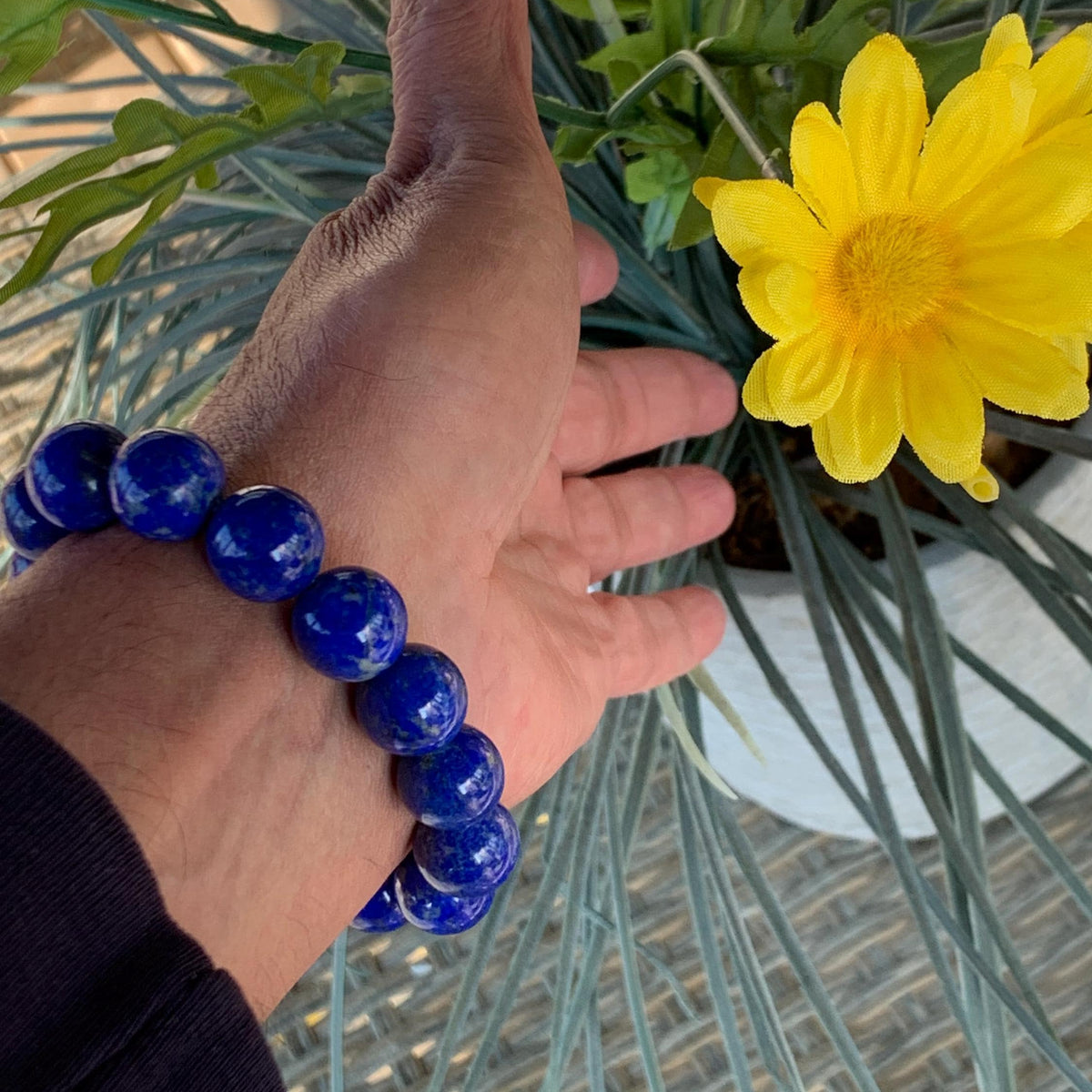 Close-up of a blue lapis gemstone bracelet featuring oversized round beads.