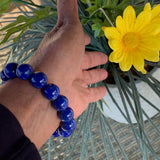 Close-up of a blue lapis gemstone bracelet featuring oversized round beads.