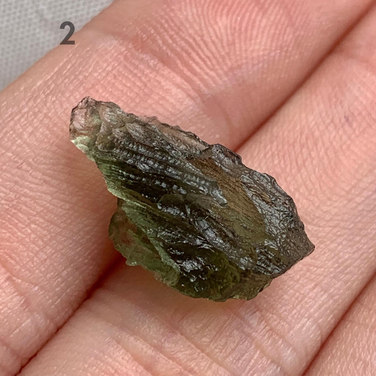 Rare Moldavite specimen showing natural texture and translucency