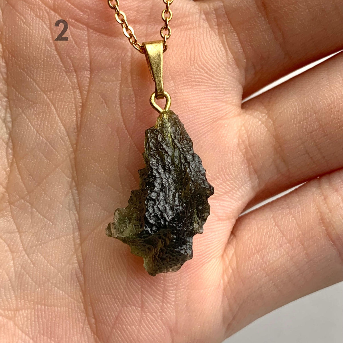 Natural moldavite specimen jewelry highlighting unique texture and shape