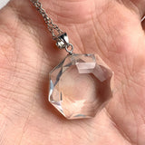 Faceted clear quartz necklace displayed showing natural crystal brilliance and reflections