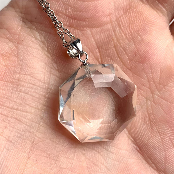 Faceted clear quartz necklace displayed showing natural crystal brilliance and reflections