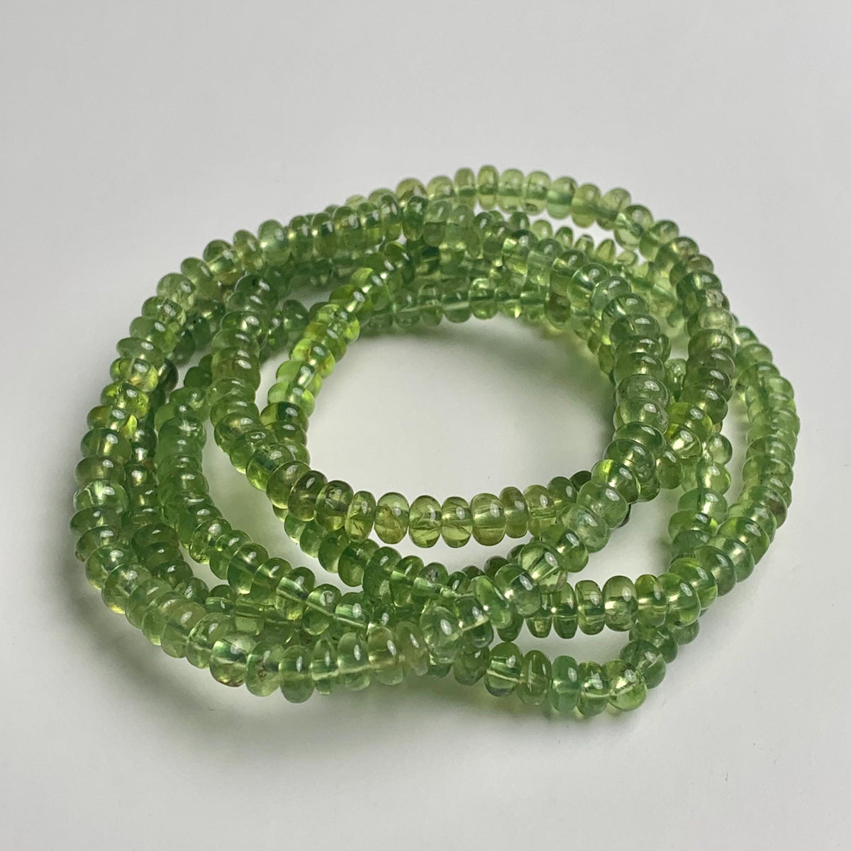 Green peridot bracelet showcasing smooth 5mm rondelle gemstone beads.
