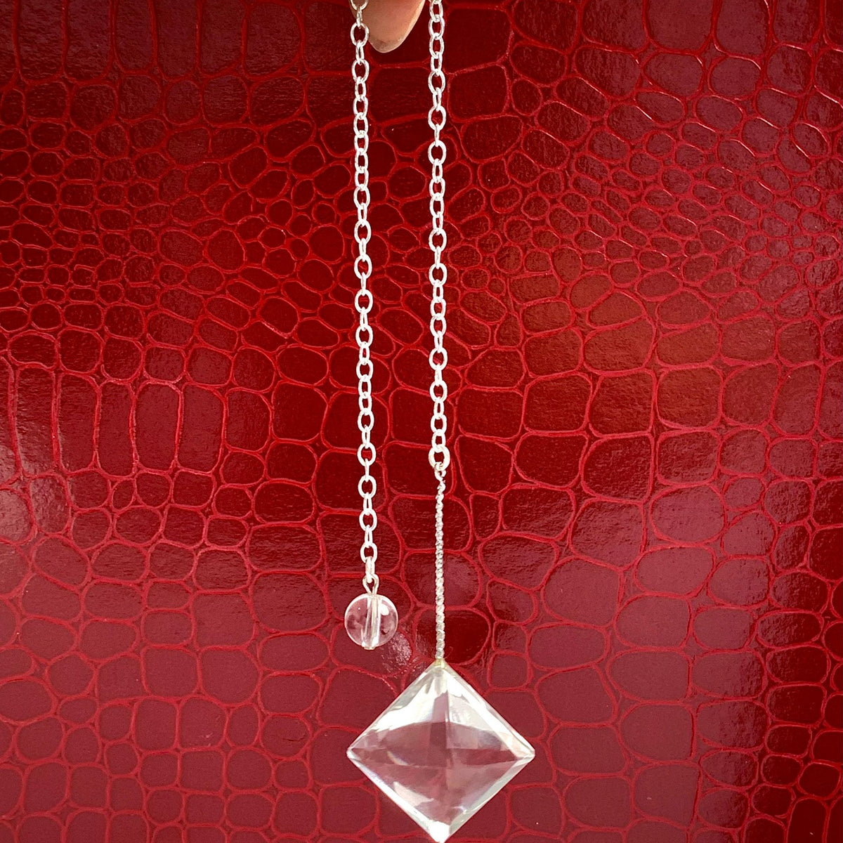 AAAA flawless clear quartz pendulum with a faceted design hanging from an 8-inch sterling silver chain.