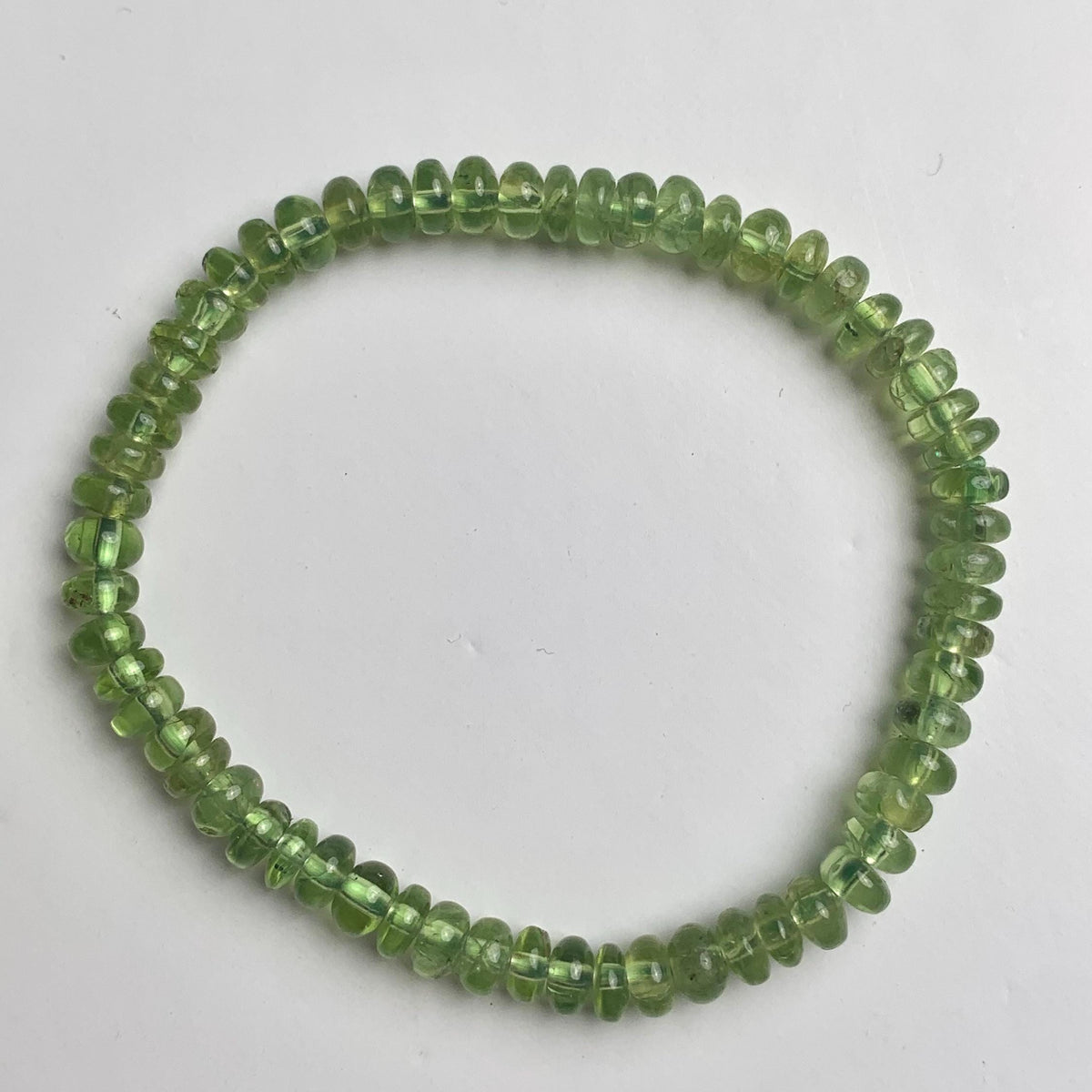 Smooth rondelle peridot beads arranged into a green gemstone bracelet