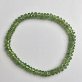 Smooth rondelle peridot beads arranged into a green gemstone bracelet