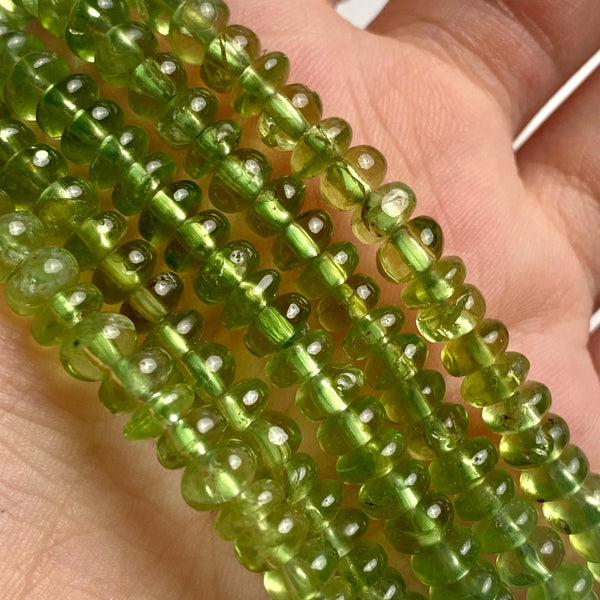 Close-up of 5mm peridot beads in a smooth rondelle shape