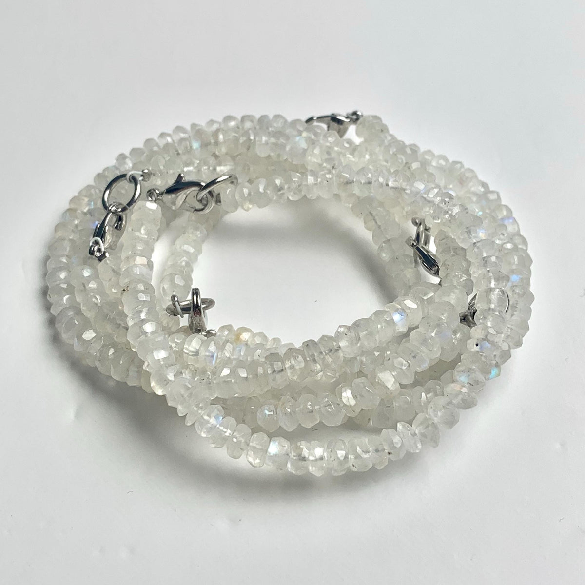 Faceted rainbow moonstone beads arranged as a blue gemstone bracelet