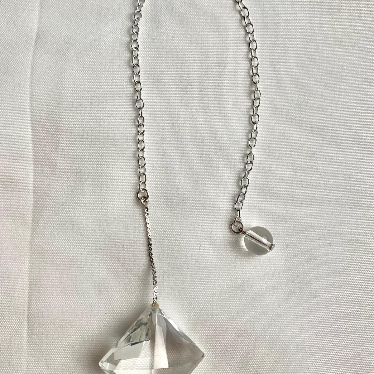 Compact faceted quartz pendulum for dowsing and crystal collections