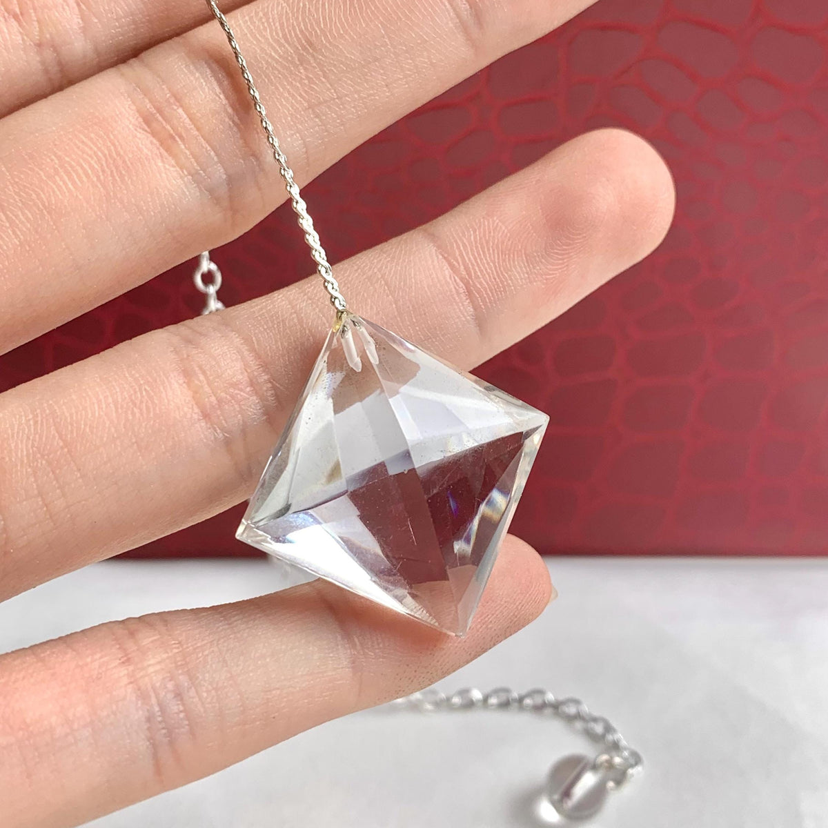 Clear quartz crystal pendulum showing its faceted finish