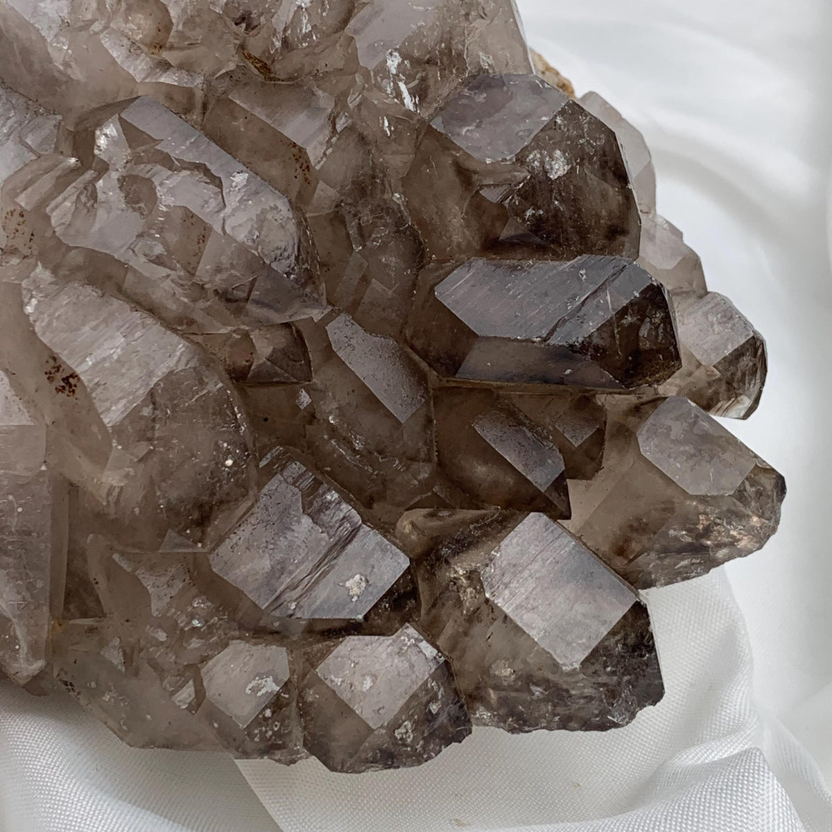 Hand-held lateral smoky quartz gwindel cluster, layered growth patterns and sparkling crystal faces in natural light