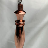 Tight frontal view highlighting faceted top and tapered point of a pure copper pendulum, ideal as a dowsing tool